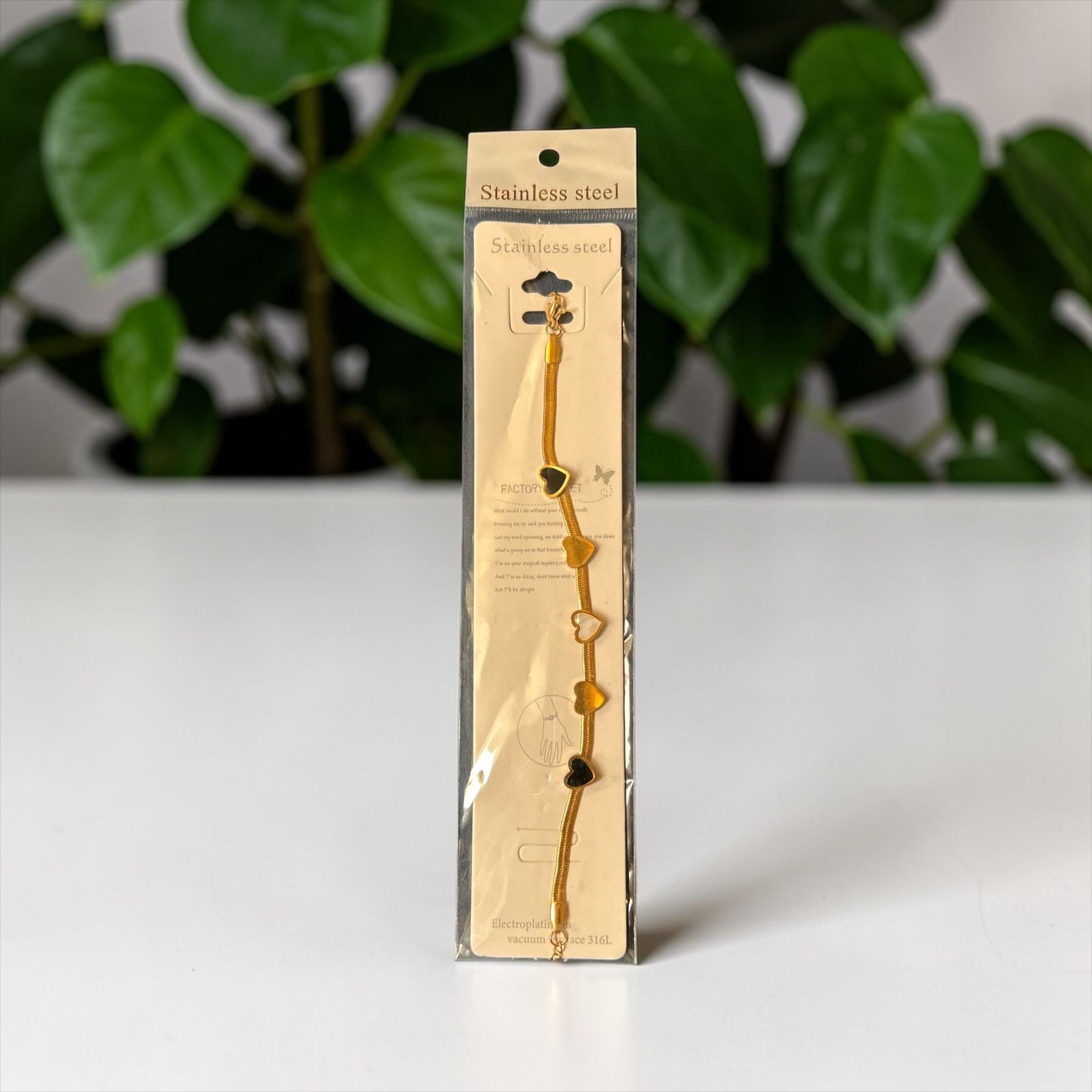Gold bracelet with black hearts charm